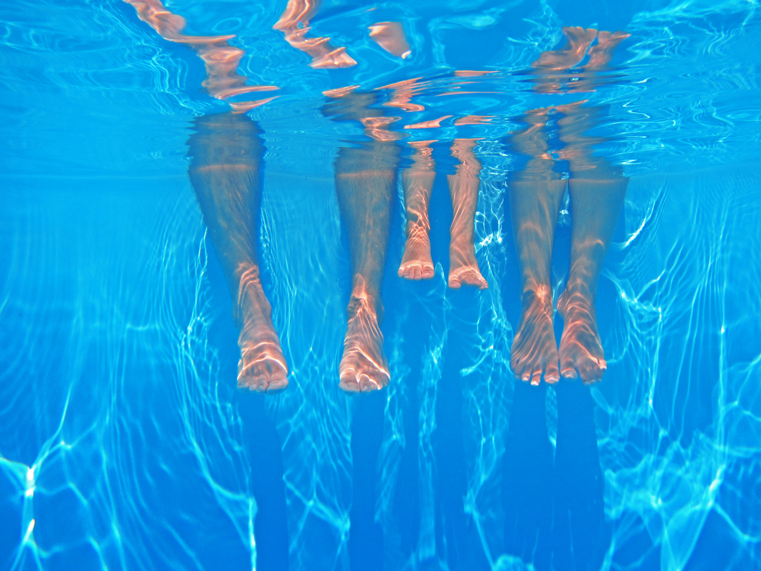 Family Dipping Their Legs in the Swimming Pool